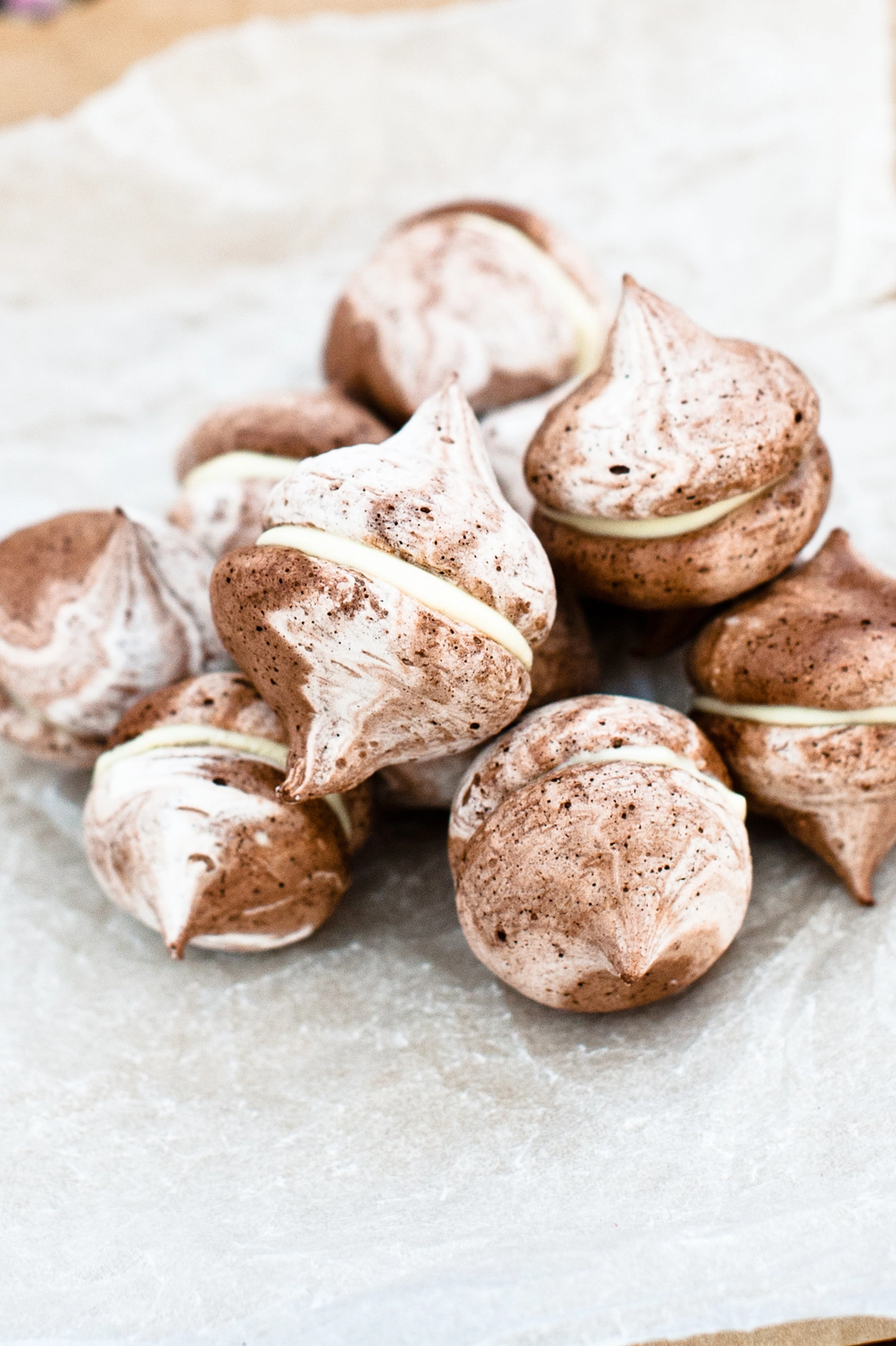 Mini Gluten free chocolate Meringue kisses stacked on partchment paper