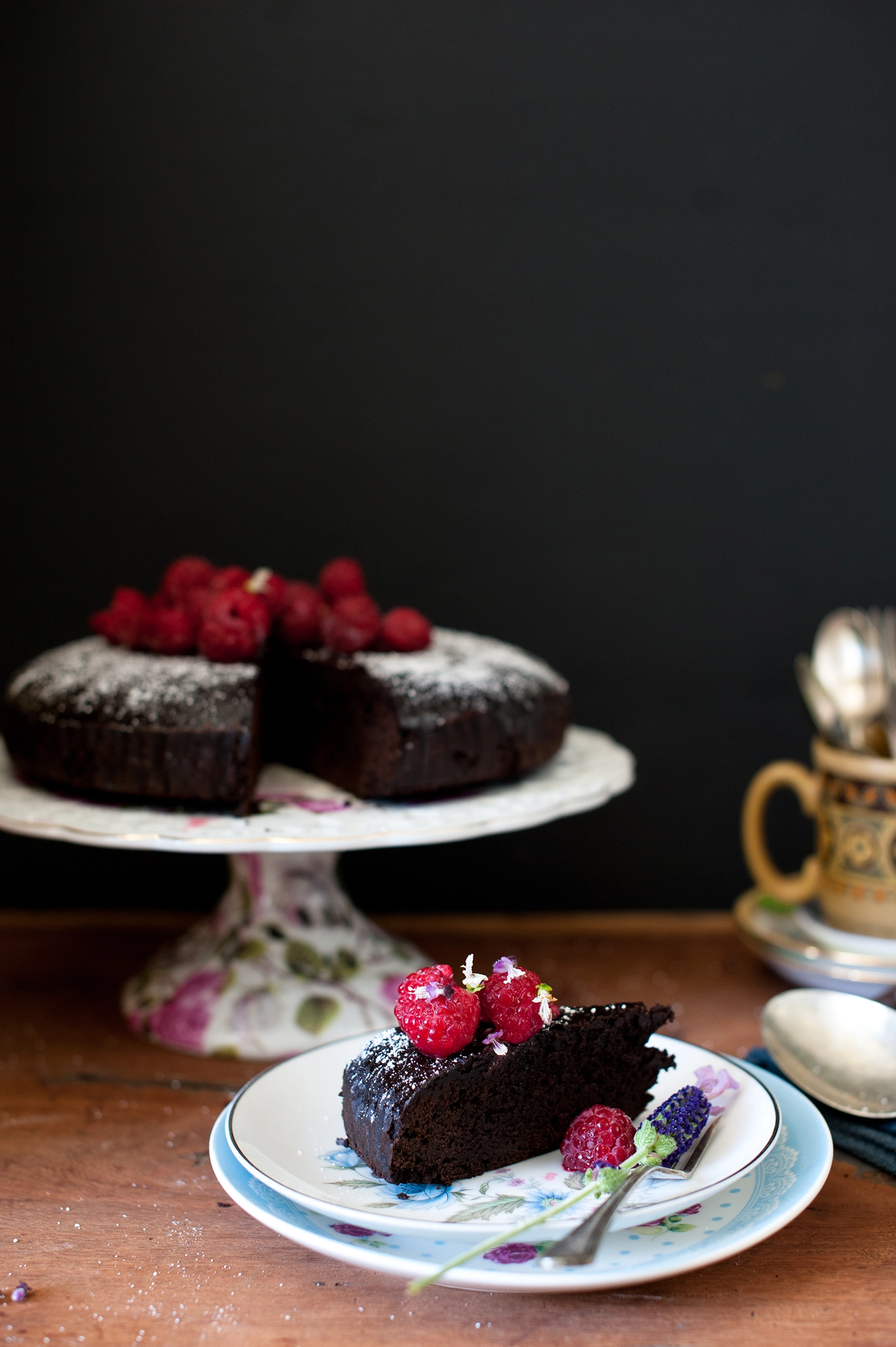 A dense, moist gluten free and dairy free chocolate mud cake made with kombucha, sliced to show its rich fudgy crumb; dark chocolate cake topped simply and perfect for allergy-friendly baking.