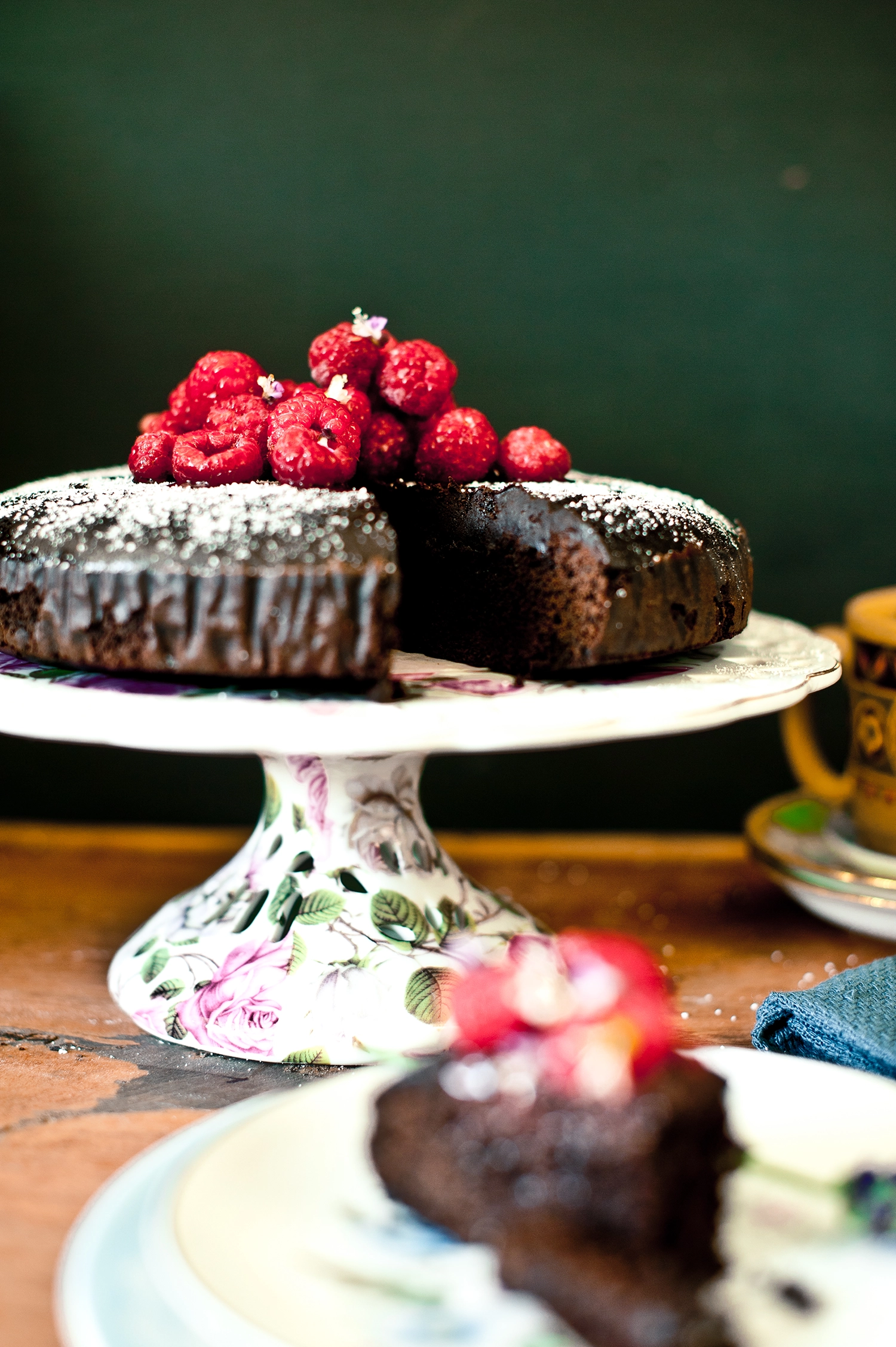 A dense, moist gluten free and dairy free chocolate mud cake made with kombucha, sliced to show its rich fudgy crumb; dark chocolate cake topped simply and perfect for allergy-friendly baking.