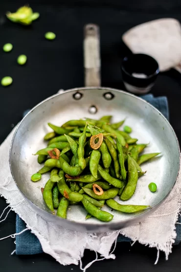 Quick and easy edamame in garlic oil — a high-protein, gluten free snack ready in 7 minutes. Perfect as a healthy side dish or lunch box addition.