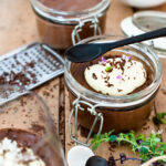 dark chocolate mousse in little glass pots topped with creme.