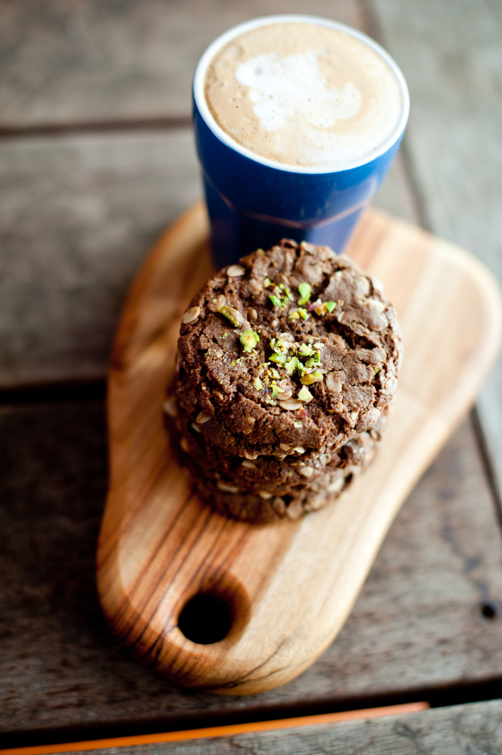stacked cafe style chocolate date anza biscuits with a coffee