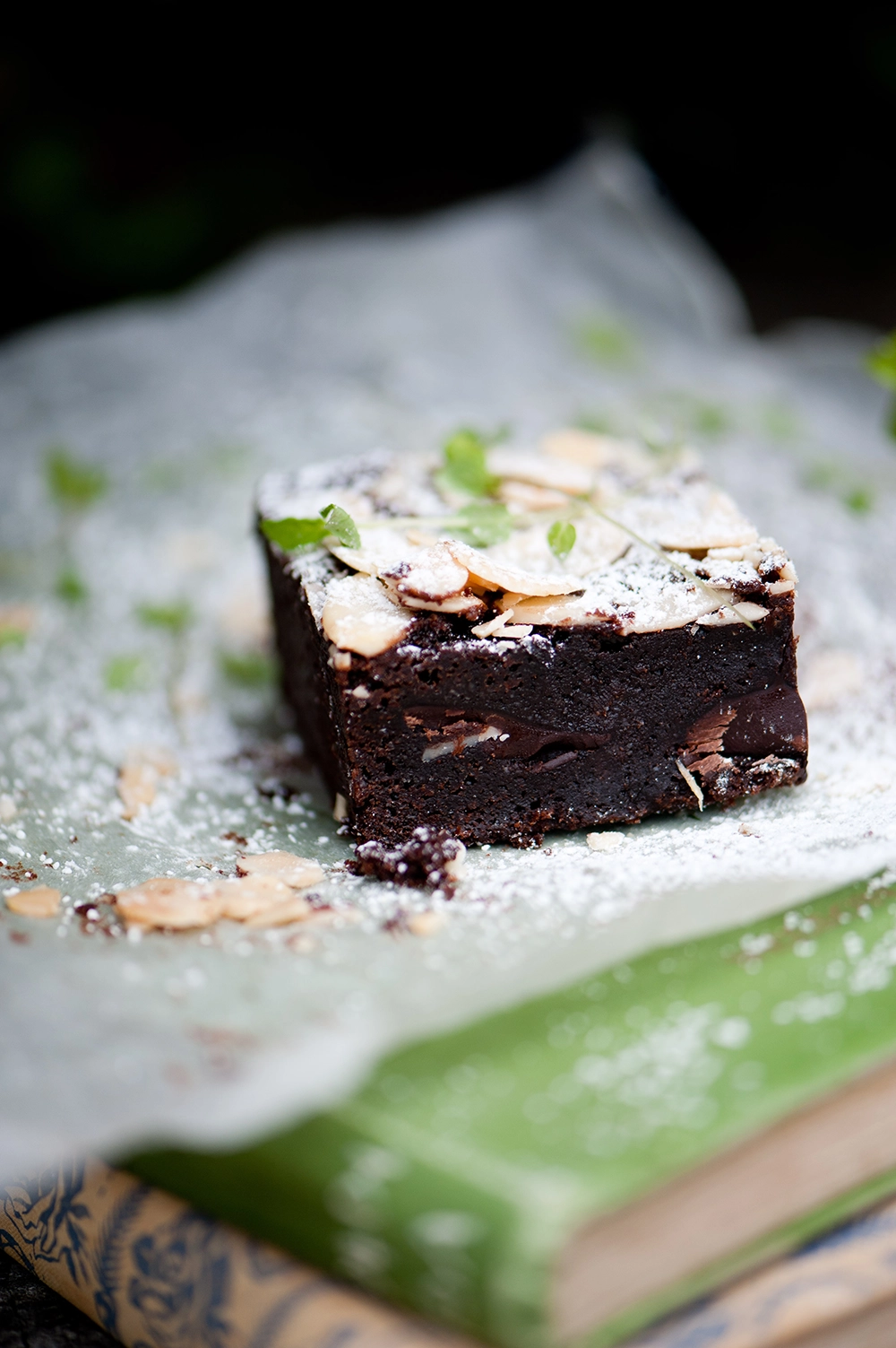 gluten free chococlate brownie dusted with icing sugar and flaked almond