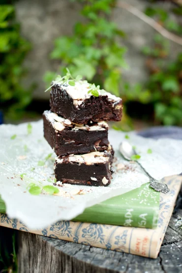 Stack of rich chocolate brownies dusted with icing sugar