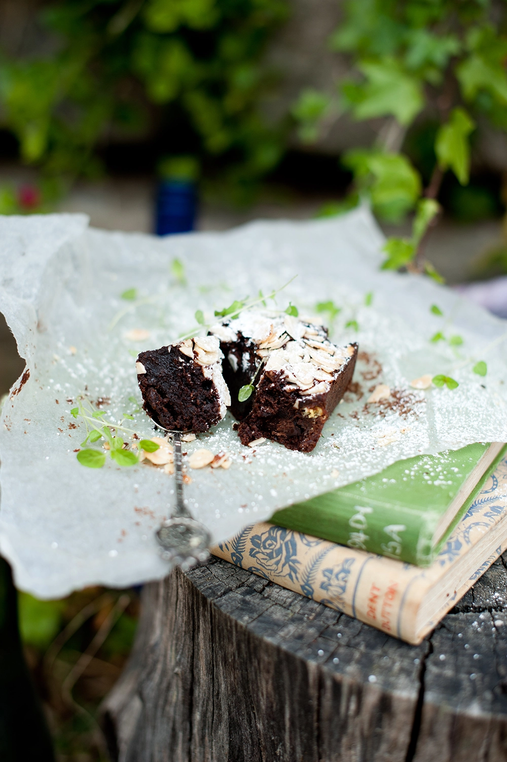gluten free chococlate brownie dusted with icing sugar and flaked almond