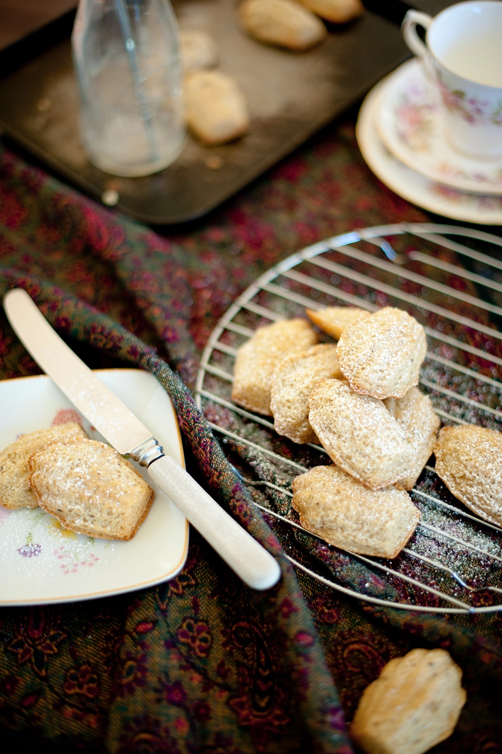 Sweet little Chai Madeleines on a cooling rack dusted with icing sugar - gluten free